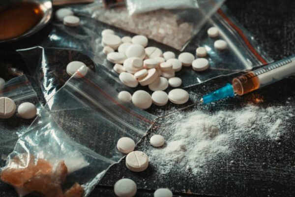 Hard drugs on dark table. Drug syringe and cooked heroin