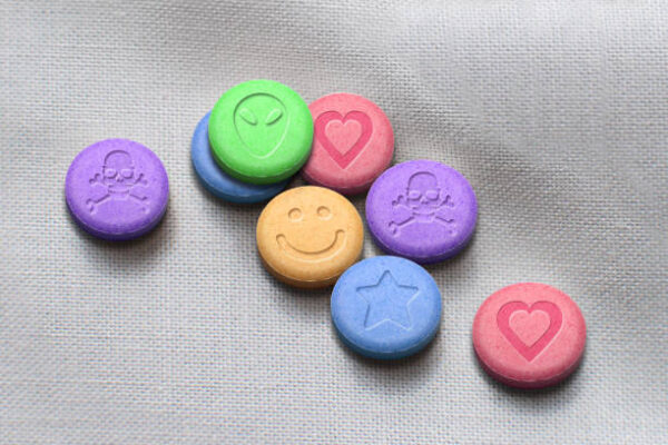 MDMA or Ecstasy pills on white fabric background